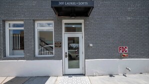 Un edificio con un letrero que dice "300 Laurel Lofts" y un hidrante marcado "FDC" en la acera.