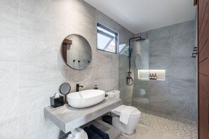 A modern bathroom with a large oval sink, a round mirror, a toilet, and a glass-enclosed shower area. - Beachfront 4BR Sunset Villa w/ Staff & Saltwater Infinity Pool (Koh Samui)