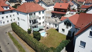 Un barrio residencial con varias casas de dos pisos, una piscina visible y un césped bien cuidado.