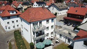 Un edificio residencial de varios pisos con piscina en la azotea y zona de estar al aire libre.