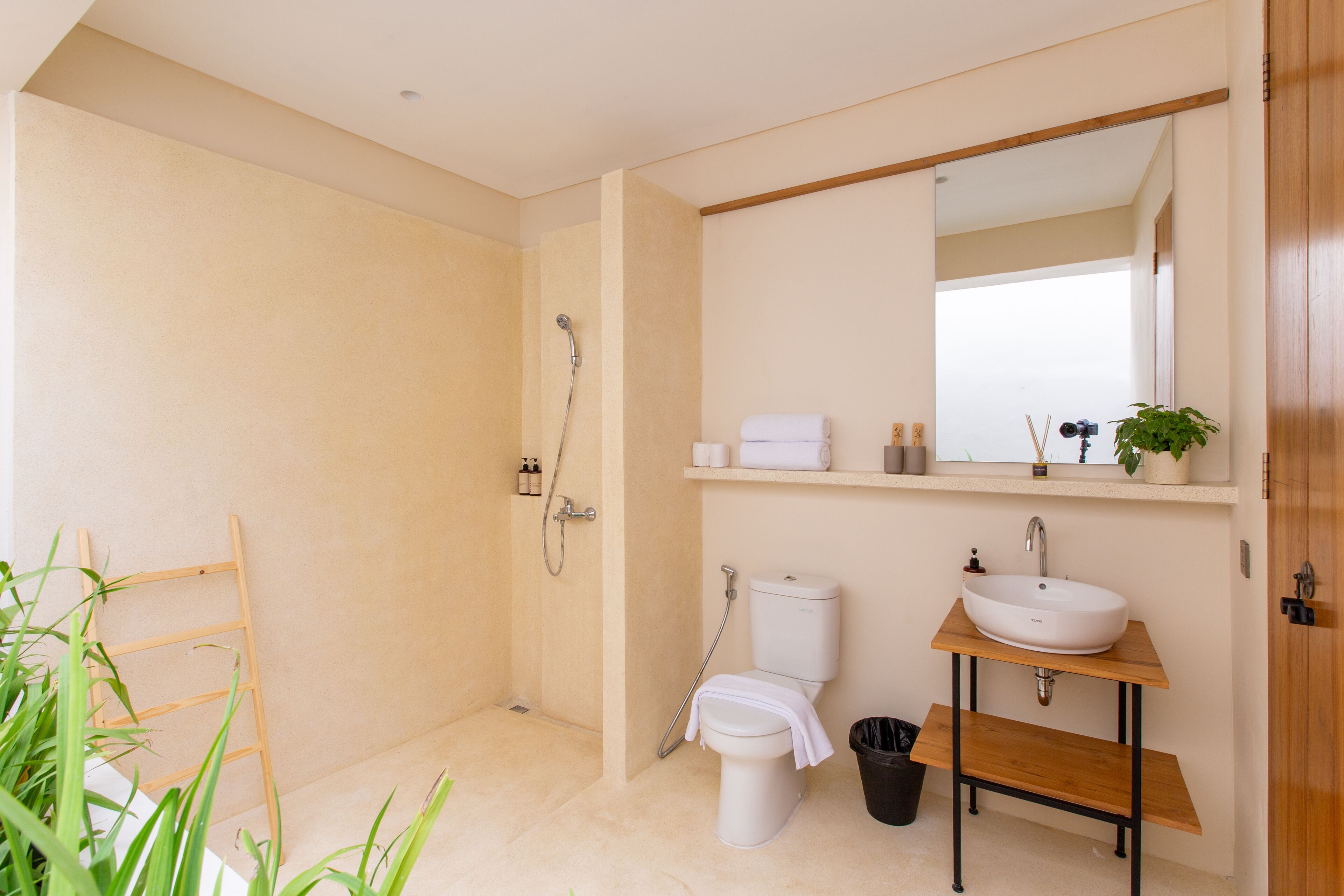 A modern bathroom with a shower, toilet, sink, and mirror.