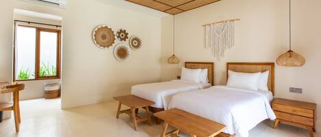 A bedroom with two beds, wooden benches, a woven ceiling, and wall decor.