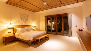 Un dormitorio con cama, mesitas de noche, un banco, techo de madera y televisor sobre un mueble de madera.