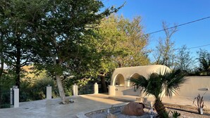A courtyard with a paved walkway, a stone wall, and a palm tree. - Riviera Vista Luxury Homes, Mousela 2broom suite with sea view and shared pool (Dramia)