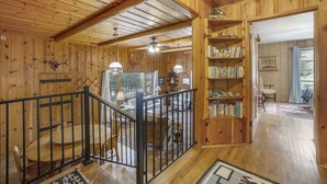 A wooden interior with a staircase, bookshelves, and a dining area. - Hidden Pines -- Ev#3034 2 Bedroom Home by RedAwning (Estes Park)