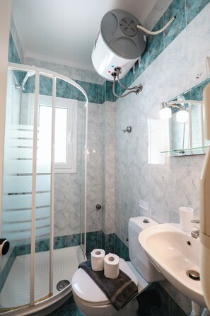 A bathroom with a shower, toilet, sink, and a mirror. - Corfu Glyfada Menigos Resort 86 (Corfu)