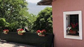 A building with a pink exterior and a window with potted flowers. - Stunning 3-bed House in Gallinaro, Aircon and Pool (Gallinaro)