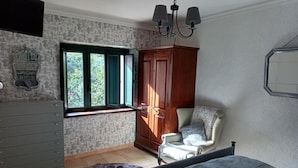 A bedroom with a bed, a chair, a wardrobe, a dresser, and a window with curtains. - Stunning 3-bed House in Gallinaro, Aircon and Pool (Gallinaro)