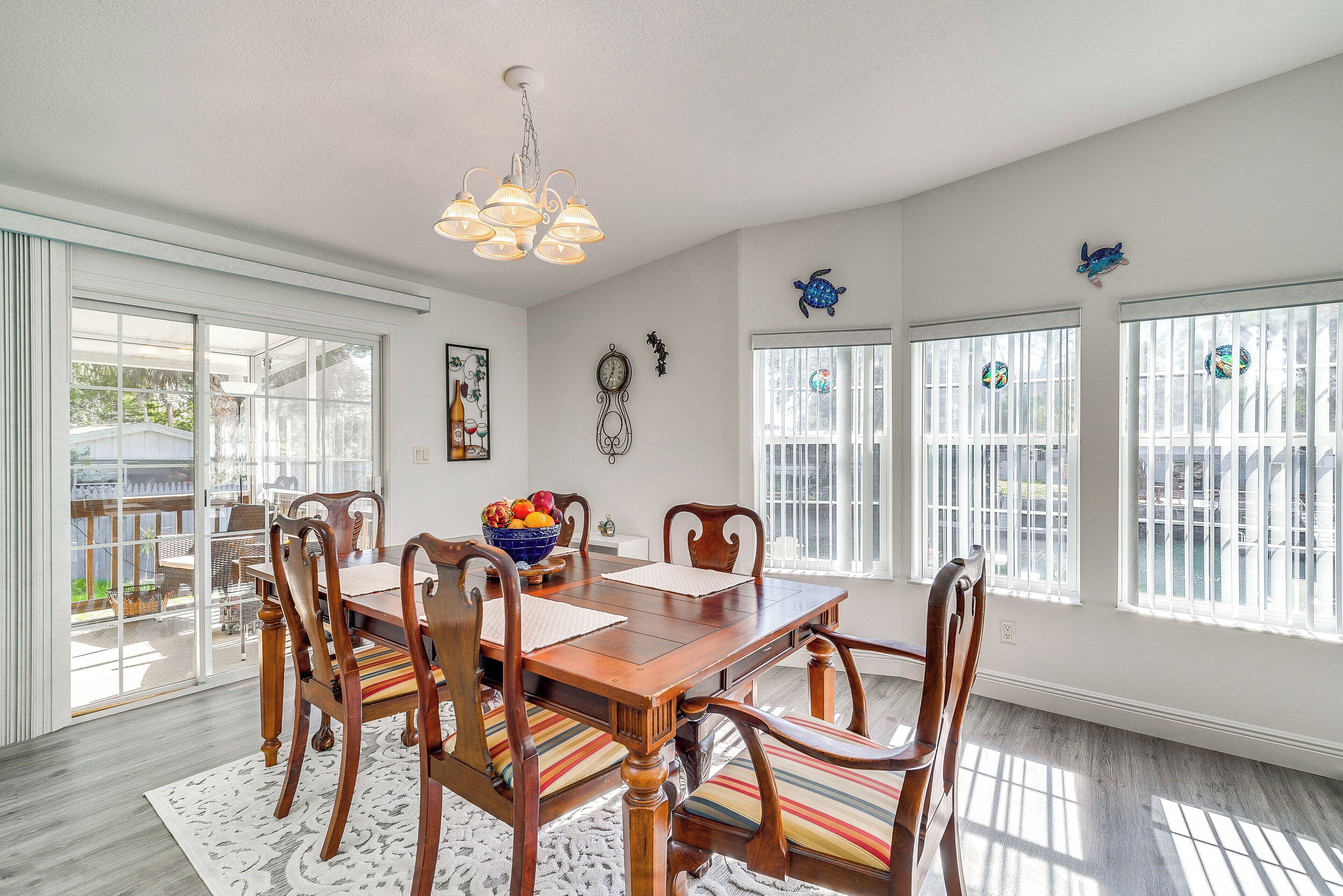 A dining room with a wooden table, chairs, and a chandelier.