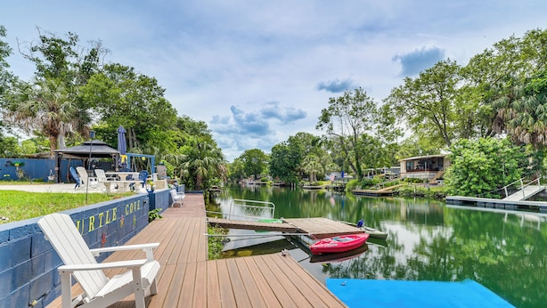 A wooden dock with a red kayak, a blue floating platform, and a sign reading "Turtle Cove".