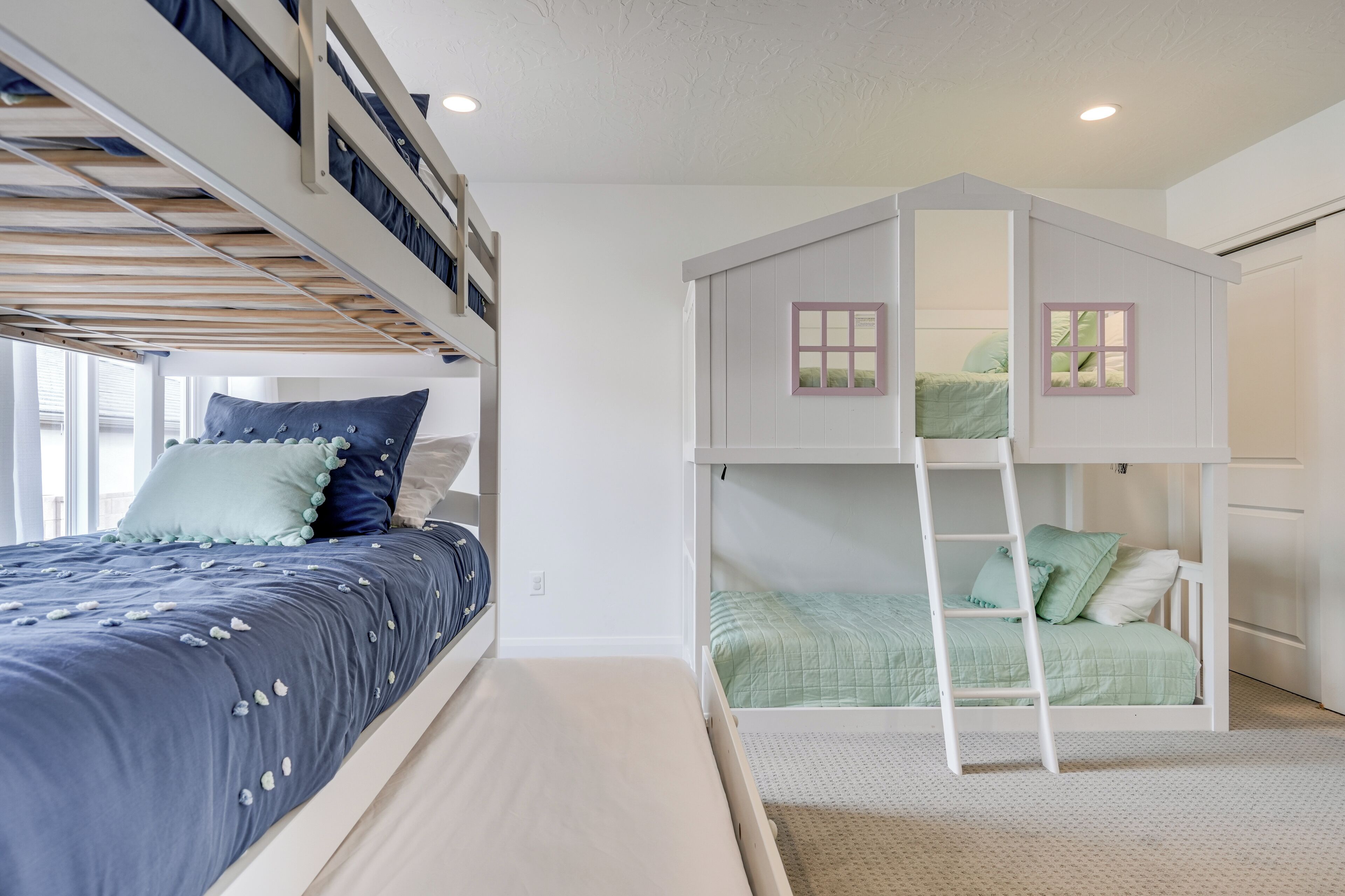 A room with a bunk bed, a loft bed, and a ladder.