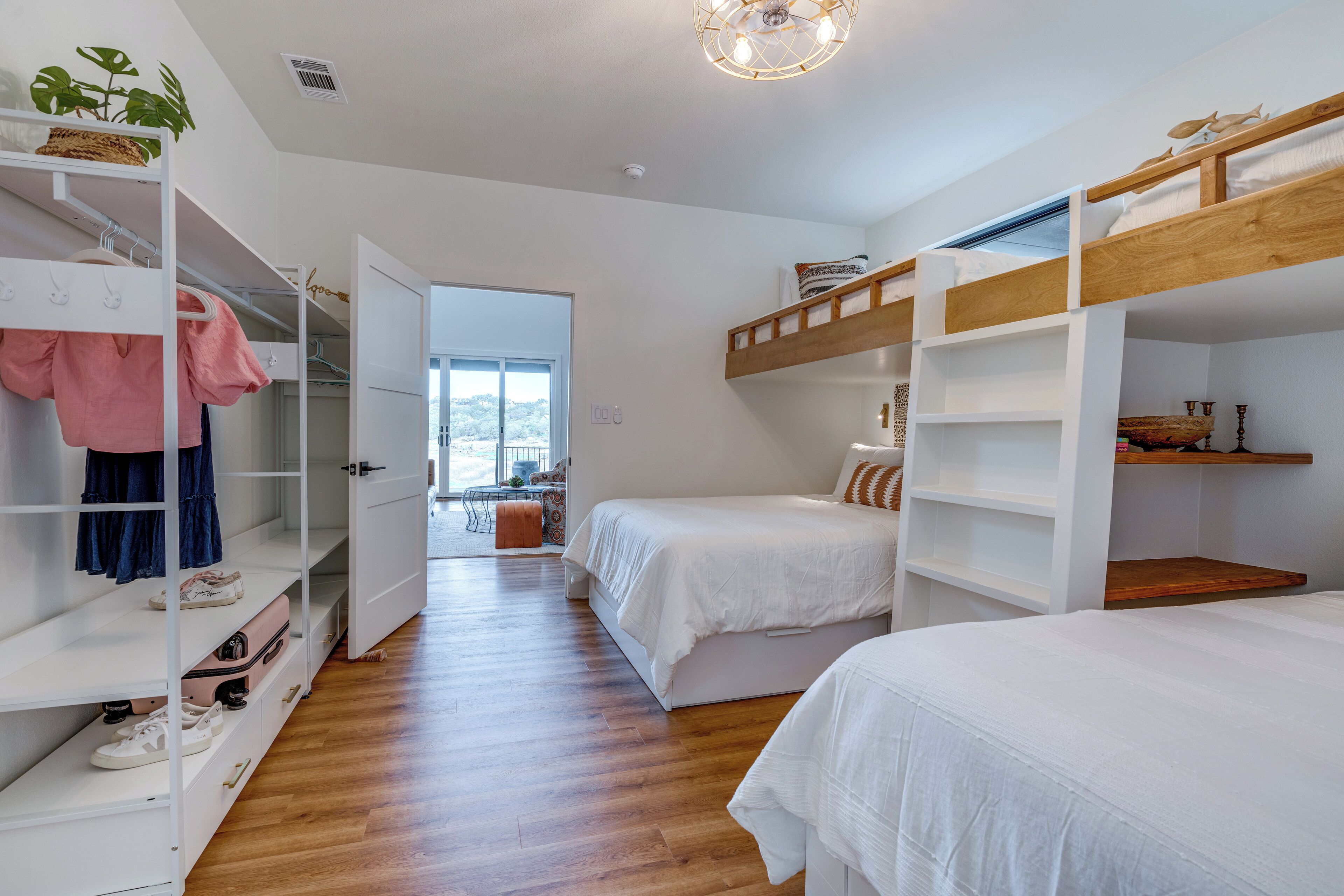 Une chambre avec des lits superposés, une armoire et un bureau avec une chaise.