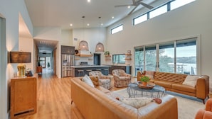 A spacious living area with a sofa, armchairs, a coffee table, and a view of the outdoors.