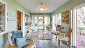 A sunlit interior with a tiled floor, a ceiling fan, and a view of the outdoors through large windows. - Auburndale Vacation Rental w/ Yard & Lake Views (Auburndale)