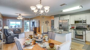 A spacious kitchen with modern appliances, a dining area with a wooden table, and a cozy living room with a fireplace. - Auburndale Vacation Rental w/ Yard & Lake Views (Auburndale)