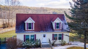 A two-story house with a red roof, white siding, and a front porch. - Mcdowell Highland County River Retreat w/ Views! (McDowell)
