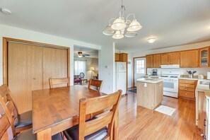 A spacious kitchen with wooden cabinets, a large dining table, and a central island. - Mcdowell Highland County River Retreat w/ Views! (McDowell)