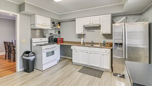 A modern kitchen with white cabinets, a stainless steel refrigerator, a stove, and a microwave. - Charming Starkville Rental ~ 2 Mi to Msu! (Starkville)