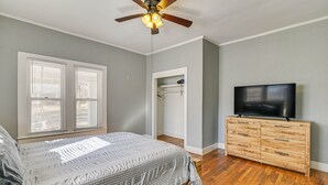 A bedroom with a bed, a wooden dresser, a ceiling fan, and a TV. - Charming Starkville Rental ~ 2 Mi to Msu! (Starkville)
