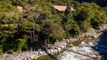 A river with a bridge, surrounded by lush greenery and hills.