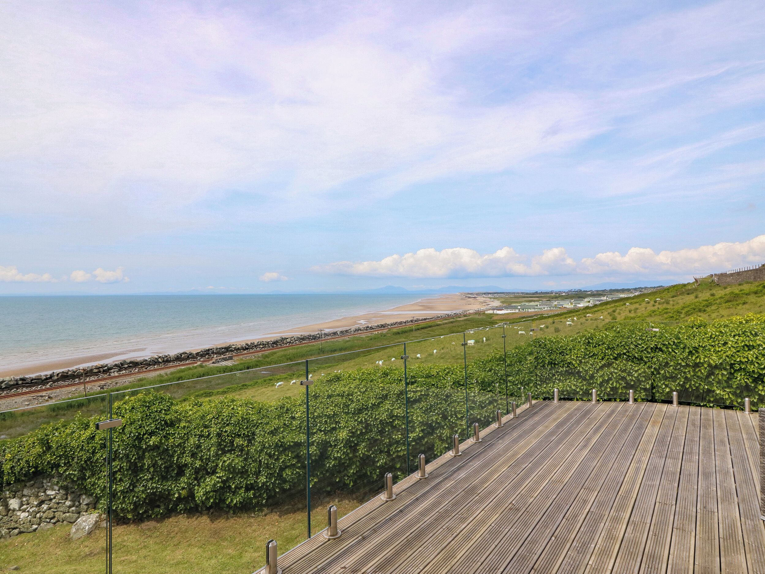 A wooden boardwalk with a view of a beach and ocean.