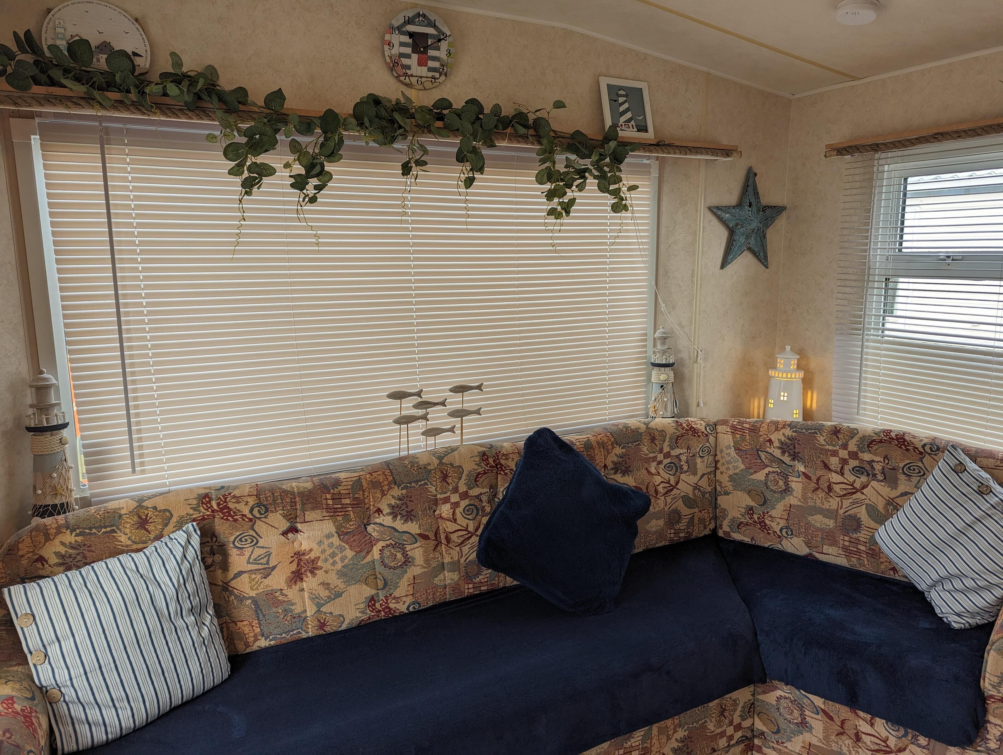 A cozy living area with a sofa, decorative pillows, a star ornament, and a clock on the wall.