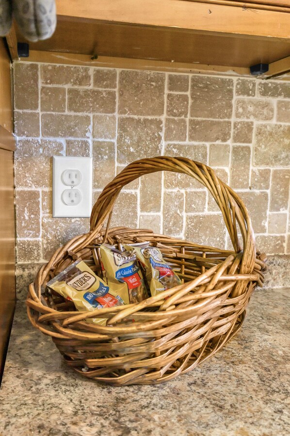 A wicker basket with packaged food items on a kitchen counter.