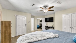 A bedroom with a bed, a ceiling fan, a TV, and a wardrobe. - 3Br, 2Ba, 6 beds, 5 min from Fort Novosel (Daleville)