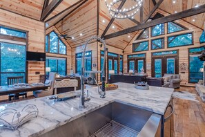 A spacious log cabin with a large kitchen area, dining space, and a cozy living room.