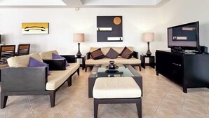 A modern living room with a sofa, armchairs, a coffee table, and a TV. - Beautiful 3-bed Villa in Cherngtalay, Thalang (Choeng Thale)