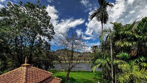 A house with a tiled roof, surrounded by lush greenery and a lake. - Beautiful 3-bed Villa in Cherngtalay, Thalang (Choeng Thale)
