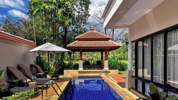 A swimming pool with a tiled deck, lounge chairs, and a covered seating area. - Beautiful 3-bed Villa in Cherngtalay, Thalang (Choeng Thale)