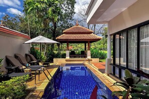 A swimming pool with a tiled deck, lounge chairs, and a covered seating area. - Beautiful 3-bed Villa in Cherngtalay, Thalang (Choeng Thale)