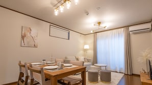 A modern living room with a dining area, a sofa, a lamp, and a large window with curtains. - Ten-Cha House - Self-Check In Only (Osaka)