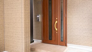 A wooden door with a glass panel and a brass handle, set in a brick wall. - Ten-Cha House - Self-Check In Only (Osaka)