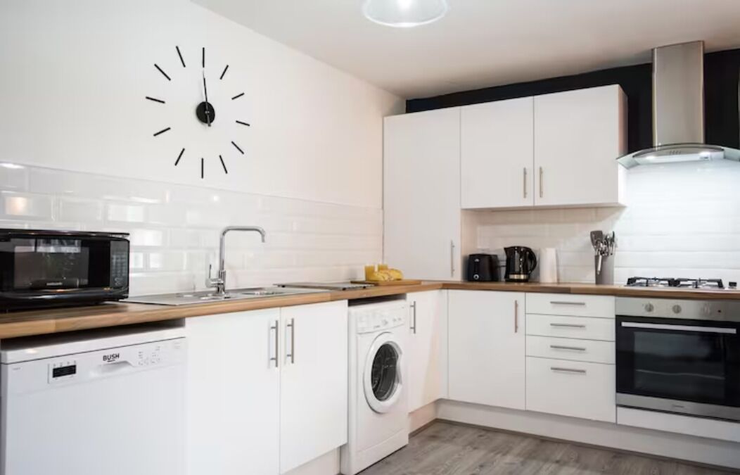 Een koelkast met diepvriezer, een microgolfoven, een oven, een kookplaat