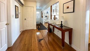 A hallway with wooden flooring, white walls, and a wooden bench. - Top Floor Apartment, Workspace, Near Downtown, ONP (Port Angeles)