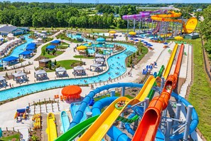 A water park with multiple slides, pools, and lounge areas. - 🌊 Salty Treat | Luxury Oceanfront | Private Heated Pool⛱️Hot Tub & Ocean Views (Corolla)