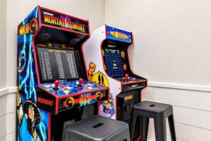 Two arcade machines, one labeled 'Midway Mortal Kombat' and the other 'Pac-Man,' with a small stool in front of them. - 🌊 Ultra-Luxury OCEANFRONT | Private Heated Pool🏖️Hot Tub & Unmatched Views! (Corolla)