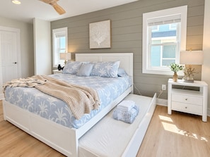 A bedroom with a bed, bedside tables, a nightstand, a window, and a ceiling fan. - 🌊 Ultra-Luxury OCEANFRONT | Private Heated Pool🏖️Hot Tub & Unmatched Views! (Corolla)