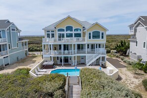 A two-story house with a pool, a covered patio, and a view of the beach. - 🌊 Ultra-Luxury OCEANFRONT | Private Heated Pool🏖️Hot Tub & Unmatched Views! (Corolla)