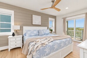 A bedroom with a bed, nightstands, a ceiling fan, and a view of the outdoors. - 🌊 Ultra-Luxury OCEANFRONT | Private Heated Pool🏖️Hot Tub & Unmatched Views! (Corolla)