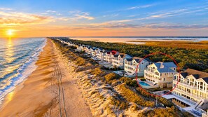 A beachfront property with multiple houses, a sandy beach, and a view of the ocean. - 🌊 Ultra-Luxury OCEANFRONT | Private Heated Pool🏖️Hot Tub & Unmatched Views! (Corolla)