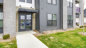 Ein modernes, zweistöckiges Mehrfamilienhaus mit Backsteinfassade, großen Fenstern und einer sichtbaren Garageneinfahrt.