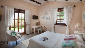 Une chambre à coucher avec un lit, un bureau, une chaise et deux fenêtres avec des rideaux.