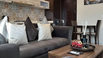 Deluxe Apartment, 1 Bedroom, Beach View, Poolside | Living area | 50-inch Smart TV with digital channels, pay films