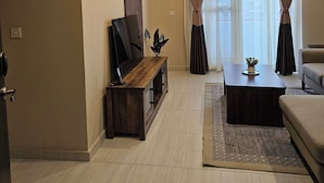 A modern living room with a wooden entertainment unit, a sofa, and a coffee table.