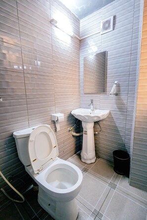 Douche, douche à « effet pluie », chaussons, serviettes fournies