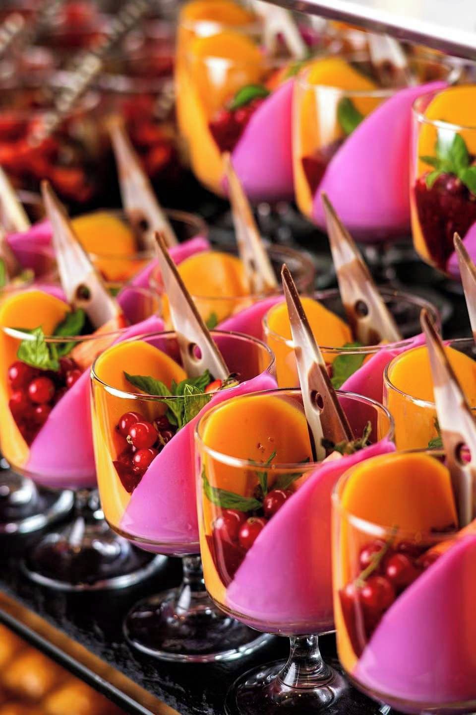 A tray of colorful fruit cocktails with a variety of fruits and garnishes.