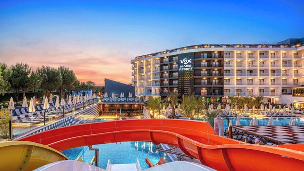 A hotel with a pool area, including a water slide and lounge chairs. - Vox Maris Resort- Ultra All Inclusive (Manavgat)